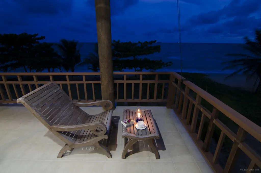 Nah Talay balcony at dusk with wooden chairs facing the sea