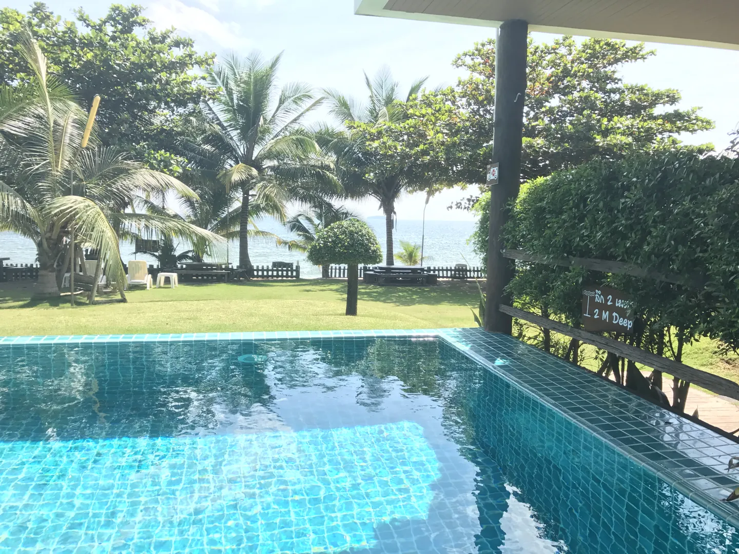 Edge of the pool with the lawn and the sea beyond