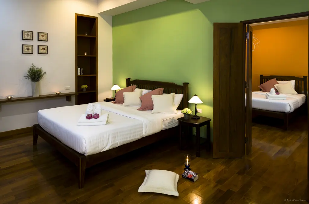 Chom Suan bedroom with double bed and door to the adjoining room